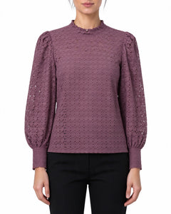 Blusa in pizzo viola con collo alto e maniche lunghe indossata, vista frontale su fondo neutro